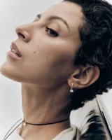 Aros dorados con diseño cruzado y una perla colgante, de la marca PDPAOLA.