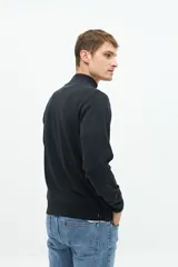 Buzo azul marino de tejido de punto con cuello alto y medio cierre con cremallera.