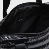 Bolso tipo tote de Bubba, confeccionado en material acolchado brillante de color negro. Cuenta con correas largas con el nombre de la marca estampado, cierre superior y compartimento interno protector para dispositivos electrónicos.