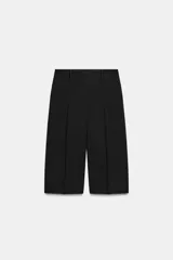 Bermuda de tiro medio color negro, confeccionada en hilatura con viscosa, con cintura con trabillas, bolsillos laterales ocultos y detalle de pinzas en el delantero.