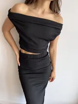 Top negro de tela bambula elastizada, con diseño off-shoulder y corte ajustado al cuerpo.