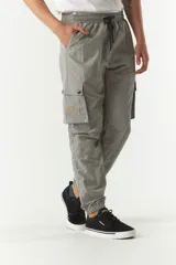 Pantalón cargo gris de nylon con cintura ajustable, bolsillos laterales con solapa y puños elásticos.