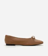 Zapatilla tipo bailarina Satinato confeccionada en cuero color tostado, con punta redondeada y detalle de mini lazo en la parte superior. Cuenta con suela plana de baja altura.