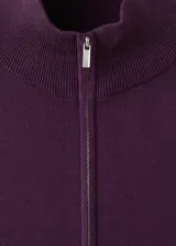 Cardigan bordó de punto con cierre frontal de cremallera y cuello alto, de manga larga con líneas blancas decorativas en las mangas.