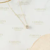 Collar minimalista con cadena fina de acero quirúrgico con baño de oro y un dije central de cristal redondo engastado en bisel.