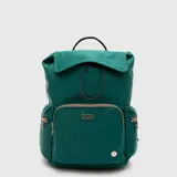 Mochila Bubba modelo Charlotte, color verde, con cierre de solapa y cordón ajustable. Presenta un bolsillo frontal con cierre, bolsillos laterales con cierre y logo metálico en el frente.