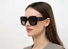 Lentes de sol INVU con montura cuadrada negra y lentes degradadas de rosa a gris.