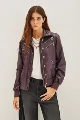 Campera estilo biker color ciruela, con múltiples cierres metálicos decorativos en el frente y mangas. Tiene cuello alto con broches, puños y cintura elastizados.