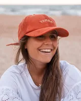 Gorro de pana color mostaza con visera y bordado frontal con la palabra "Yamba".