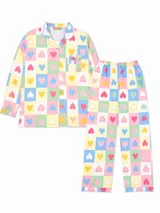 Camisa de pijama de manga larga con cuello solapa y cierre frontal de botones, confeccionada en tela con estampado de cuadros multicolor y corazones. Incluye un bolsillo frontal en el pecho.