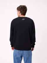 Buzo de cuello redondo Rusty, confeccionado en tejido de algodón y poliéster, con diseño liso en color beige, puños y ruedo acanalados, y detalle de etiqueta de la marca en el frente.