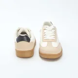 Zapatillas bajas de lona color blanco y beige con suela marrón.