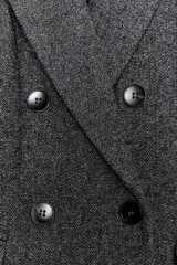 Blazer de corte oversize en color gris jaspeado, con cuello solapa, hombreras y cierre frontal cruzado con botones. Cuenta con bolsillos delanteros con solapa.