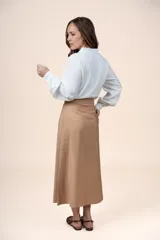 Falda midi de tiro alto color tostado, con diseño recto y fluido, confeccionada en mezcla de rayón y poliéster.