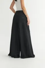 Pantalón jean negro de pierna ancha, corte holgado y tiro medio.