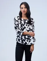 Blusa de gasa satén estampada con diseño animal print en tonos naranja y negro, de la marca Ninety. Tiene mangas tres cuartos y cuello redondo.
