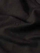 Camisa negra de algodón orgánico, corte slim, manga larga, cuello clásico y cierre frontal con botones.