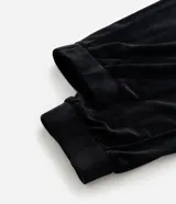 Pantalón jogger de plush color negro, con cintura elástica, bolsillos laterales y puños ajustados en los tobillos.