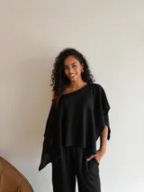 Blusa de tejido waffle color marrón, con diseño asimétrico de un solo hombro y mangas anchas tipo capa.