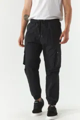 Pantalón cargo gris de nylon con cintura ajustable, bolsillos laterales con solapa y puños elásticos.
