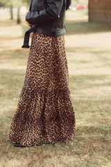 Vestido largo strapless con estampado animal print y cinturón ancho con apliques metálicos.