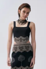 Vestido corto negro de tejido de punto con técnica jacquard, escote cuadrado, tirantes anchos y falda con estampado de árboles plateados.