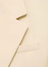 Chaqueta tipo blazer de corte recto y diseño cruzado con cierre de botones. Presenta cuello con solapas de muesca, manga larga con puños abotonados y bolsillos delanteros con solapa.