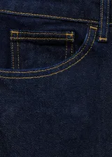 Pantalón de jean de corte recto y tiro medio, en color azul oscuro con costuras en contraste. Presenta diseño clásico de cinco bolsillos, cierre frontal con cremallera y botón, y trabillas para cinturón.