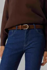 Cinturón de gamuza color marrón oscuro con hebilla metálica dorada de diseño clásico.