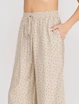 Palazzo de tiro alto color beige con estampado de lunares, cintura elastizada con cordón de ajuste y corte de pierna ancho.