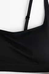 Sujetador suave de punto color negro, con tirantes ajustables y copas forradas con relleno extraíble. Presenta un ribete de canalé en el bajo y no tiene cierre.