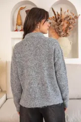 Sweater gris de tejido de punto con cierre frontal de cremallera y cuello alto. Decorado con lentejuelas brillantes en la parte delantera.