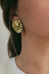Aros colgantes dorados con forma de hoja, hechos en bronce.