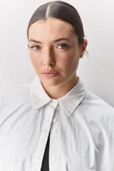 Camisa de algodón de calce relajado con cuello clásico, mangas largas con puños abotonados y cierre frontal con botones.