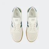 Championes New Balance CT500 color crema con detalles en azul y suela marrón de goma.