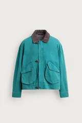 Cazadora boxy fit de algodón con efecto lavado, color verde, cuello de pana marrón a contraste y grandes bolsillos con solapa en la parte delantera. Presenta cierre frontal con alamares metálicos.