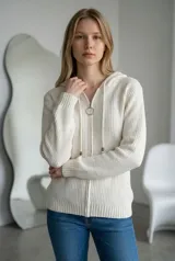 Sweater tipo campera de tejido de punto acanalado en color crudo, con cierre frontal completo, capucha con cordones ajustables y puños y ruedo tejidos en rib.