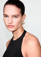 Top peplum negro con cuello halter, sin mangas y diseño entallado.