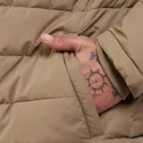 Campera parka acolchada de hombre, color beige, con cierre frontal de botones, cuello de cotelé en contraste y bolsillo en el pecho con solapa.