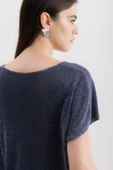 Blusa de punto con acabado brillante, cuello redondo y mangas cortas con caída relajada.