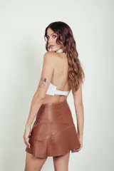 Minifalda acampanada de cuero color caramelo con costuras decorativas en hilo blanco.
