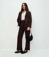 Blazer femenino de sastrería confeccionado en tejido Punto Roma, con cuello solapa, cierre frontal con ganchos y botones decorativos dorados con escudo grabado.
