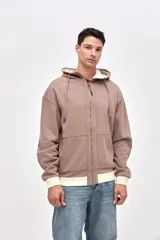 Canguro con cierre frontal metálico, confeccionado en felpa con friza. Presenta capucha con interior en contraste, cuello alto, bolsillos laterales y detalles de bordado de la marca en el pecho y las mangas. Posee un calce relajado con puños y ruedo en contraste.