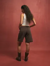 Short de jean color gris oscuro, tiro alto, con dobladillo ancho en el ruedo y corte recto que llega por encima de la rodilla.