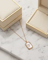 Collar de acero con baño de oro, compuesto por una cadena fina y un dije rectangular con incrustación de nácar y una circonia central.