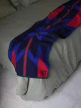 Bufanda grande de punto con estampa geométrica inspirada en diseños Navajo, en combinación de tonos azul, rojo y verde.