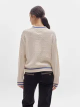 Pantalón de pana roja con corte holgado y tiro medio. Presenta una línea dorada a lo largo de la pierna.