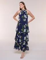 Vestido maxi Julia Jordan de gasa estampada azul con flores blancas y hojas verdes, escote halter y diseño estructurado en paneles volados.