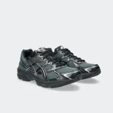 Championes Asics modelo Gel 1130, color blanco con detalles plateados y verde oscuro. Diseño retro inspirando en el running con tecnología GEL en el talón.