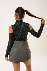 Polera negra con lurex, cuello alto, mangas largas y aberturas en hombros y pecho.